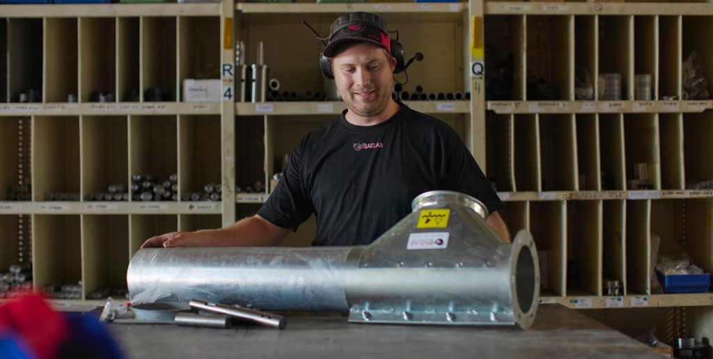 Man i Rais ab tröja arbetar med ett transportrör