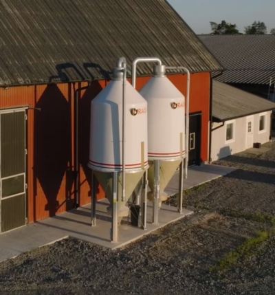 Två mikrofibersilos bredvid en röd lada