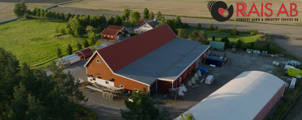 Ladugård och hus sett från ovan bredvid fält.