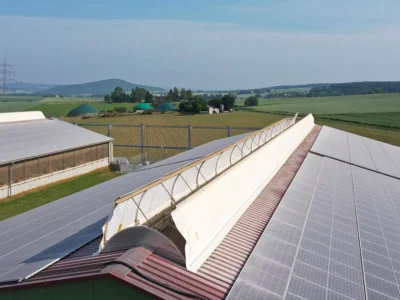 Utsidan av en lada med nockventilation och solceller på taket.