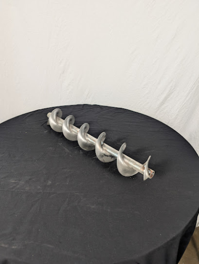 Spiral 50 centimeter på ett svart bord framför en vit duk.