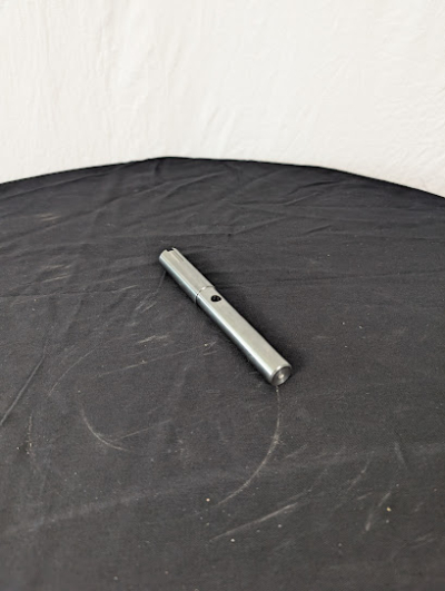 En kedjeaxel på ett svart bord framför en vit duk.