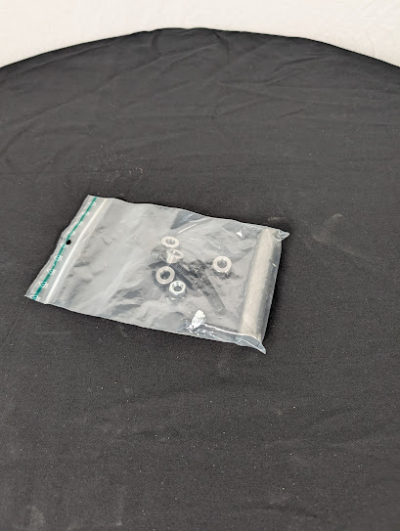 En påse med en skarvaxel inklusive bultar.