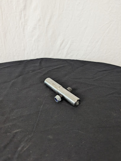 En drivaxel på ett svart bord framför en vit duk.