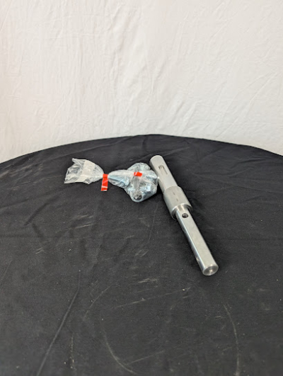 En drivaxel på ett svart bord framför en vit duk.