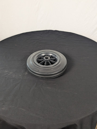 Hjul på ett svart bord framför en vit duk.