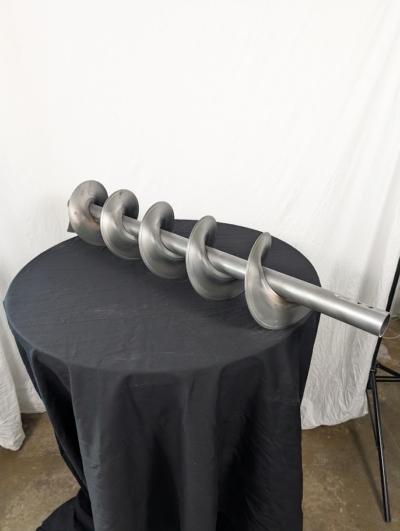 Spiral 1 meter på ett svart bord framför en vit duk.