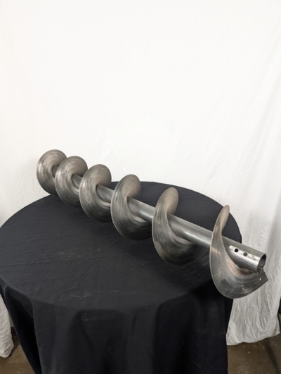 Spiral 1 meter på ett svart bord framför en vit duk.