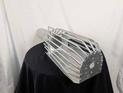 Förläning inlopp med skyddskorg på svart duk framför vit duk.