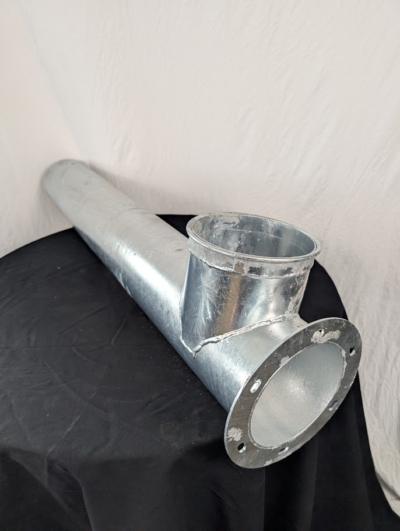 Förläning utlopp med fläns på svart duk framför vit duk.