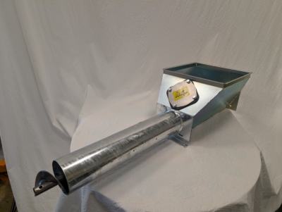 Förlängning inlopp S Kupa i metall på ett vittklätt bord framför en vit duk.